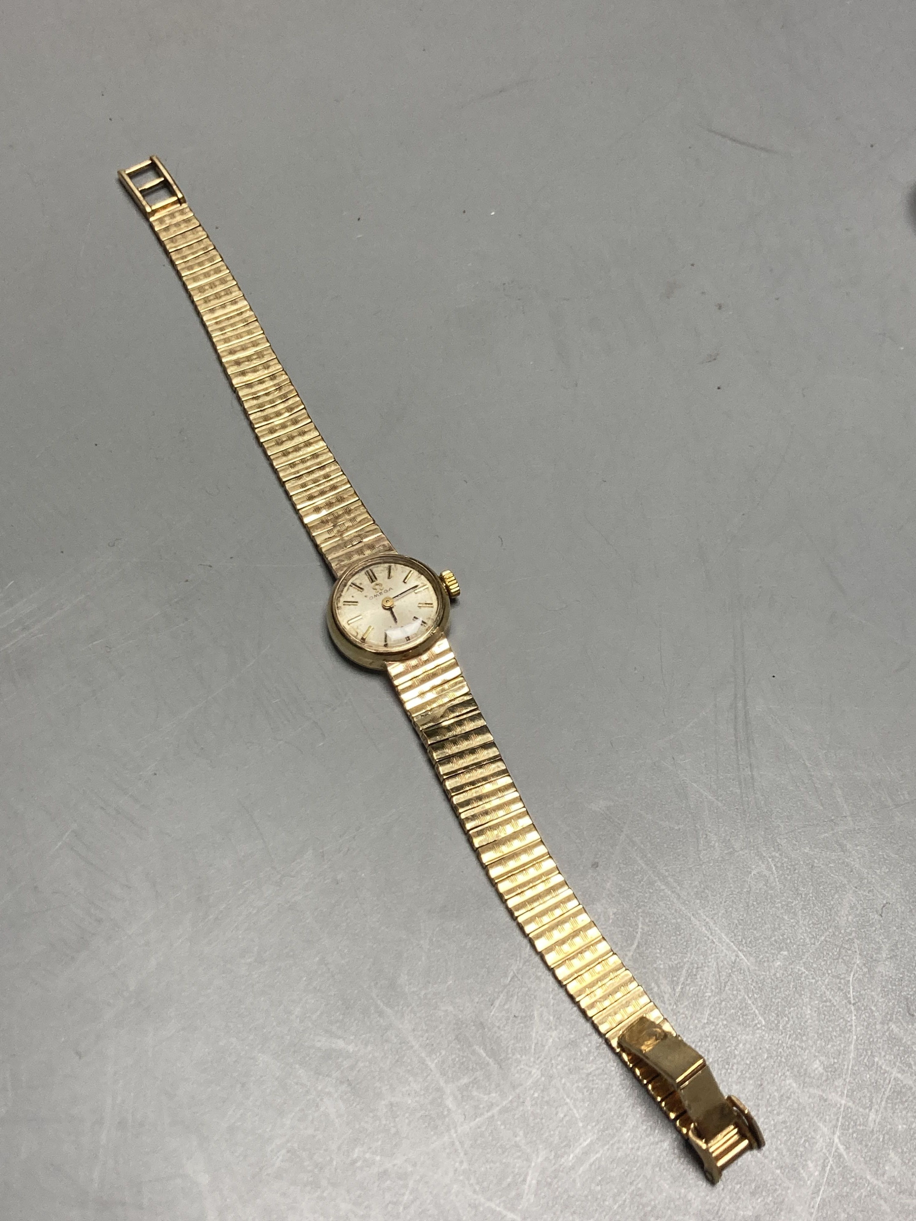 A ladys 1960s 9ct gold Omega manual wind wrist watch, on a 9ct gold Omega bracelet, overall length 18.5mm gross 21.3 grams,